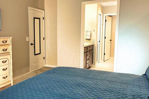 a bedroom with a blue bed and a bathroom at Serenity In The Villages in The Villages