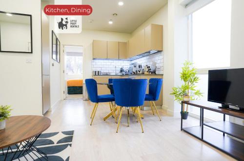 a kitchen with blue chairs and a dining room at 2 Bedroom Apartment By Littlepiggyrentals Short Lets & Serviced Accommodation Stevenage With Free Parking, Gym & Roof Garden in Stevenage