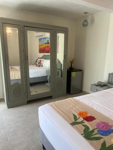 a bedroom with a bed and a mirrored cabinet at Hotel Boutique Flores y Gemas in Mérida