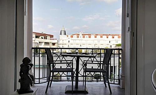 d'un balcon avec une table et des chaises et une vue sur un bâtiment. dans l'établissement LA CROISETTE élégant studio avec balcon et vue mer aperçu, à Cannes
