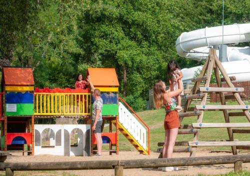 a group of children playing on a playground at Camping Le Ty Nadan - Eurocamp I Homair in Locunolé