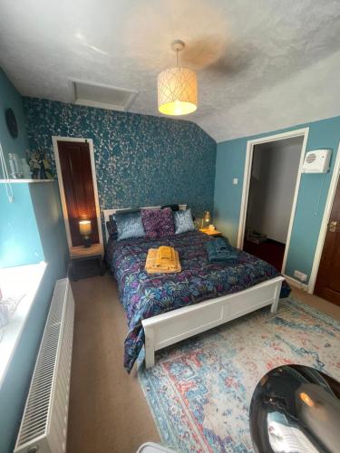 a bedroom with a bed and a blue wall at The Bolthole in Nailsworth