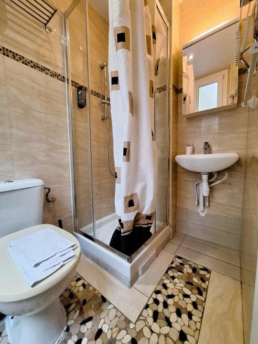 une salle de bain avec une douche, des toilettes et un lavabo dans l'établissement Hipotel Paris Gambetta République, à Paris