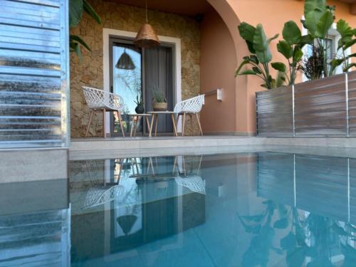 a swimming pool with two chairs and a table at Nomas Living in Kalamaki