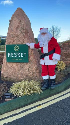 a statue of santa claus standing next to a sign at 12 Field Views - 2 Bedrooms 2 bathrooms - 1 shower - 1 bath No sign written vans in High Hesket