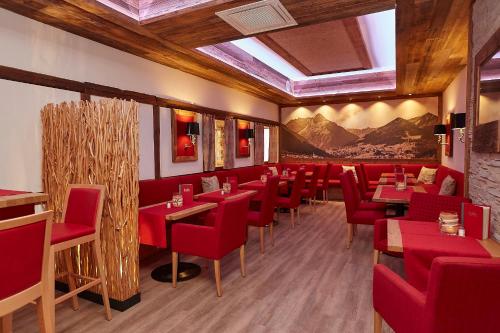a restaurant with red chairs and tables in a room at Hotel Am Kamin in Kaufbeuren