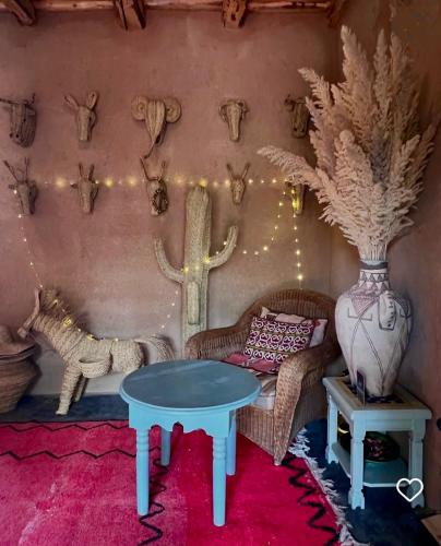 a living room with a table and a couch at Agafay Desert Hotel in El Karia