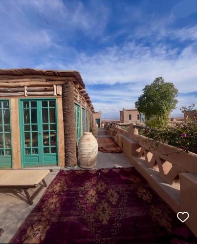a building with a vase sitting on a rug at Agafay Desert Hotel in El Karia
