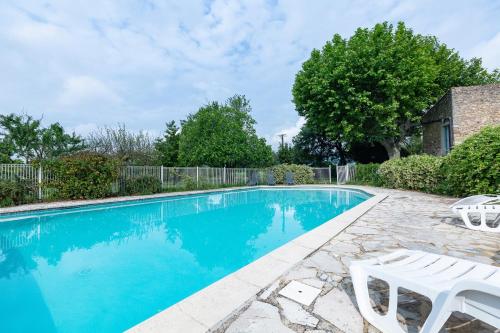 a swimming pool with two white chairs next to it at Maison de campagne au calme in Roynac