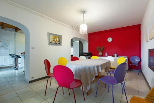 a dining room with a table and colorful chairs at Maison de campagne au calme in Roynac