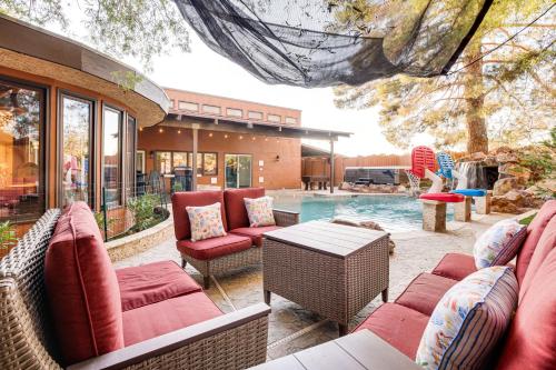 a patio with chairs and a table and a pool at 1-Acre Las Vegas Getaway Pool, Spa and Tennis Court in Las Vegas