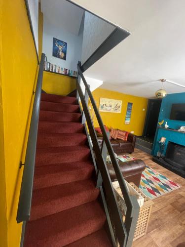 a stairway in a living room with yellow walls at The Bolthole in Nailsworth