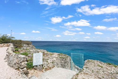 a sign on the side of a cliff near the ocean at Bon Azul 5A in Westpunt