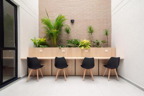 a counter with four chairs and plants on a wall at Hotel Estar in Manizales