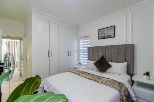 a bedroom with a large white bed in a room at Luxurious sandton apartment with Inverter in Sandton