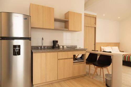 a kitchen with a stainless steel refrigerator in a room at Hotel Estar in Manizales