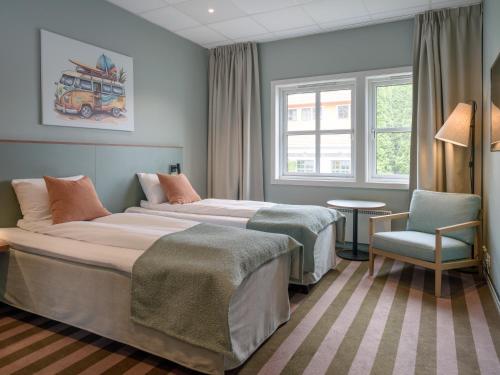 a hotel room with two beds and a chair at Quality Hotel Sarpsborg in Sarpsborg