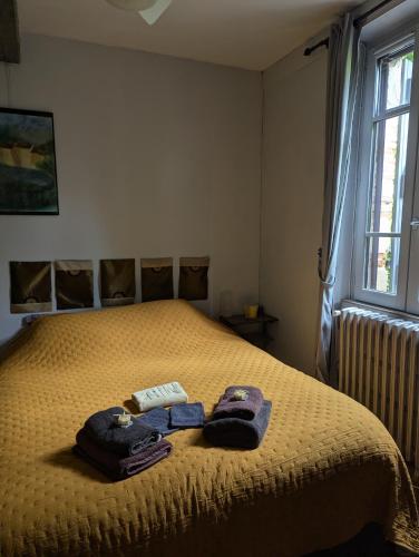 une chambre avec un lit avec deux serviettes dessus dans l'établissement Gîte de la Tour Donjon, à Belcastel