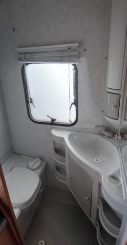 a small bathroom with a toilet and a sink at Belle caravane au calme in Persac