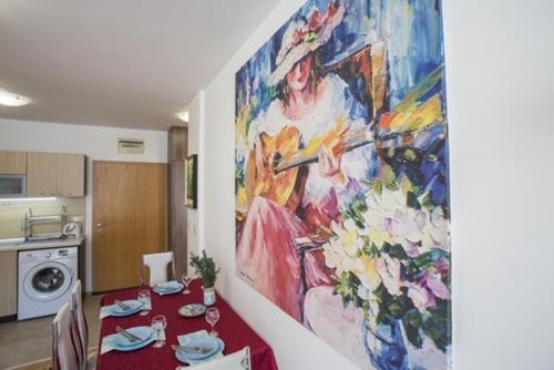 a dining room with a painting on the wall at Mountain view apartment in Aspen Golf Resort with SPA in Bansko