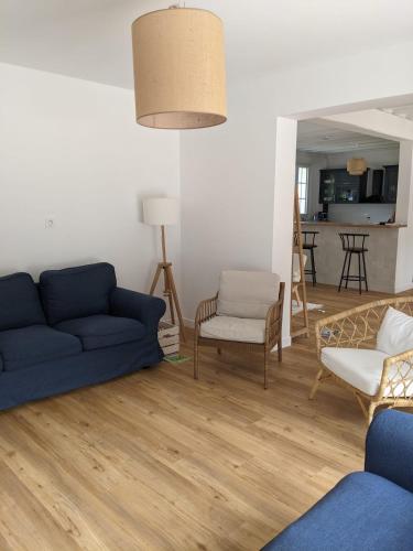 un salon avec un canapé bleu et des chaises dans l'établissement La Demeure Bleue - Idylliq Collection, à Vénesville