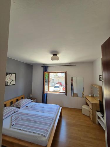 a bedroom with a large bed and a window at Apartmani Vini in Hvar