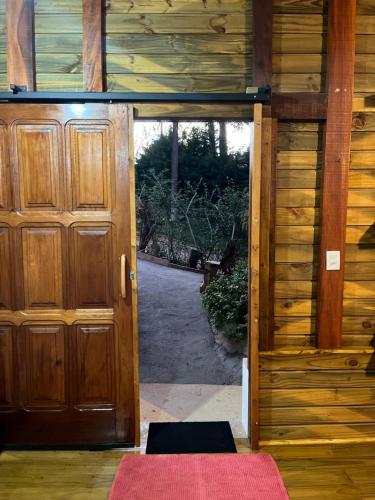 an open door of a wooden house with a porch at Almazen da vivi in Monte Verde