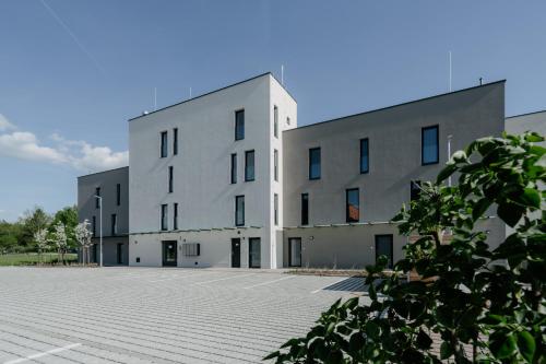a large white building with a parking lot at RELAX PARK Třeboň III in Třeboň