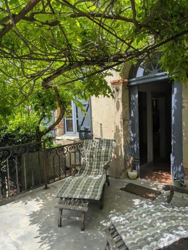 une paire de bancs assis sur un patio dans l'établissement Gîte de la Tour Donjon, à Belcastel