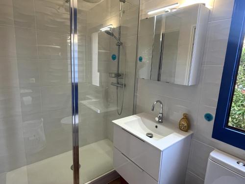 une salle de bain blanche avec une douche et un lavabo dans l'établissement Appartement RDC avec terrasse et animaux admis - 4 couchages à St Cyprien - FR-1-753-32, à Saint-Cyprien