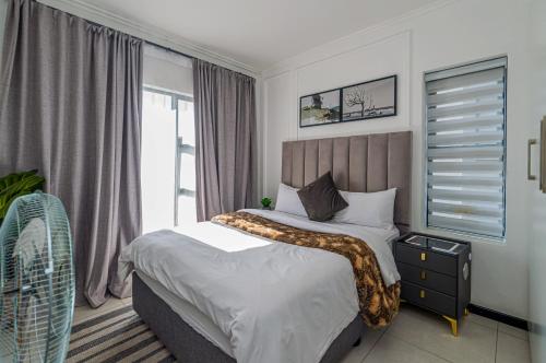 a bedroom with a bed and a window at Luxurious sandton apartment with Inverter in Sandton