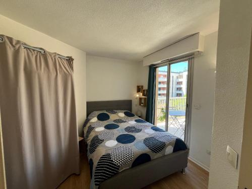 - une chambre avec un lit doté d'une couverture en point de polka dans l'établissement Appartement 2Pièces à Fréjus Plage avec Garage - FR-1-466A-53, à Fréjus
