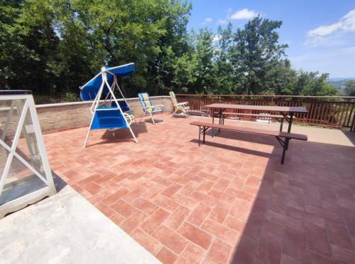 a patio with a picnic table and a swing at Happy Tuscany in Rigomagno