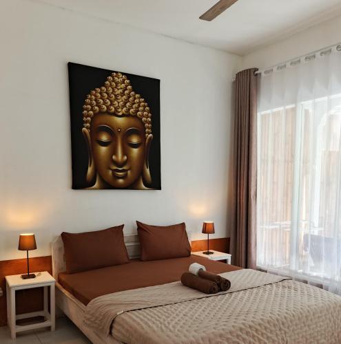 a bedroom with a bed with a large gold headboard at Wombat's B&B in Gili Trawangan