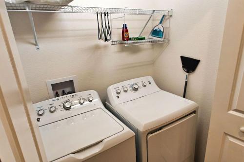 a small kitchen with a stove and a washer at Serenity In The Villages in The Villages