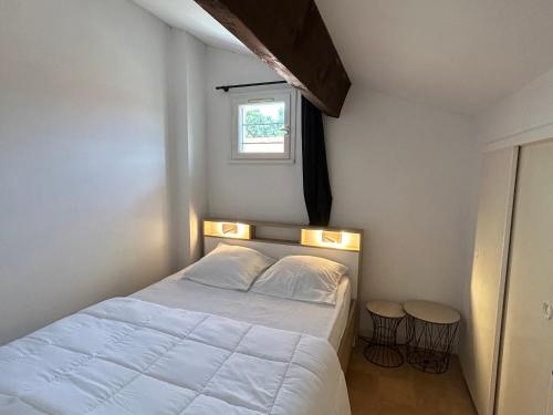 - une chambre avec un lit, une fenêtre et deux tabourets dans l'établissement Pavillon à Argelès-sur-Mer - 4 Pers., Terrasse, Parking, à 10 min de la Plage - FR-1-732-106, à Argelès-sur-Mer