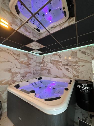 - une baignoire dans une chambre dotée d'un mur en marbre dans l'établissement Ô Saphir Spa - Maison N2, à Denain