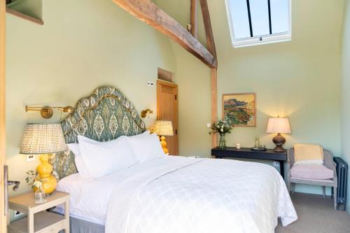 a bedroom with a large white bed and two chairs at The Wheatsheaf 