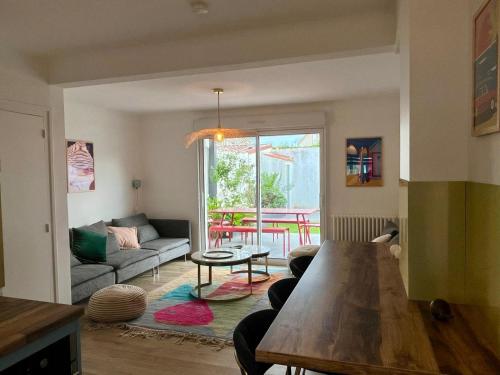 un salon avec un canapé et une table dans l'établissement Maison spacieuse au calme avec jardin - 3 chambres confortables, à Les Sables-dʼOlonne