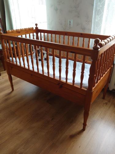 a wooden bed sitting on top of a wooden floor at Dzīvoklis Vecliepājā in Liepāja