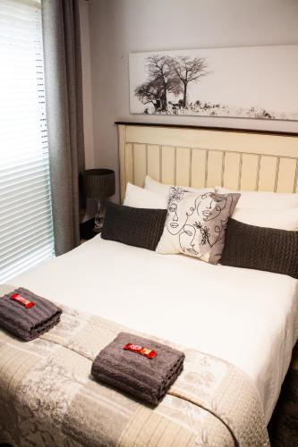 a bedroom with a bed with two towels on it at SantoSea in Mossel Bay