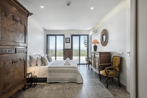 a bedroom with a bed and a desk and chairs at La Glycine in Castro Marim