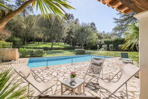 un patio avec des chaises et une piscine dans l'établissement Magnifique villa avec piscine privee, à Mougins