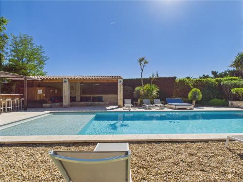 une piscine avec deux chaises et une maison dans l'établissement Magnifique Mas Provençal avec Piscine à Eygalières - 19 Couchages, 8 Chambres, Billard, et Plus ! - FR-1-599-3, à Eygalières
