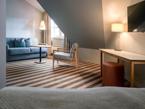 a room with a couch and a chair and a table at Quality Hotel Sarpsborg in Sarpsborg