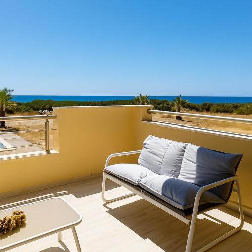 a chair on a balcony with a view of the ocean at Paliochora Beachfront Escape, Milolithos Pool Retreats in Palaiochora