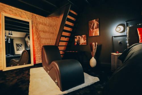 a room with a chair and a spiral staircase at Love Room L'Entre Nous in Thairé