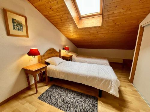 - une chambre mansardée avec 2 lits et une fenêtre dans l'établissement Appartement calme avec piscines et salle de sport - FR-1-624-29, à Samoëns