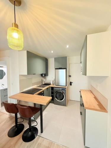 - une cuisine avec une table et un lave-linge/sèche-linge dans l'établissement Cosy Sully - T1 - Place Verdun, à Pau