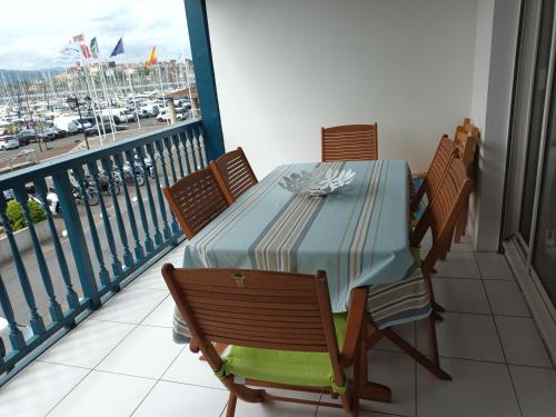 une table sur un balcon avec vue sur un port dans l'établissement Spacieux T2 à Hendaye avec parking à deux pas de la plage - FR-1-239-794, à Hendaye